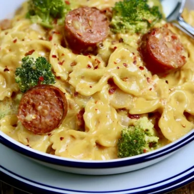 Cozy smoked sausage cheddar pasta served in a bowl, garnished with herbs