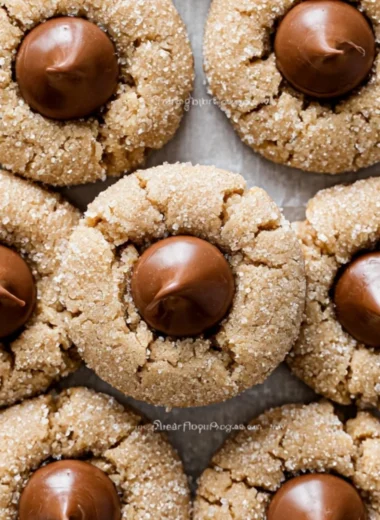 Freshly baked Peanut Butter Blossoms with chocolate kisses on a cooling rack