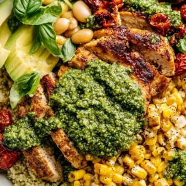 A plate of delicious pesto chicken garnished with fresh basil and cherry tomatoes.