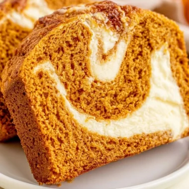 Slice of pumpkin bread with cream cheese frosting on a plate