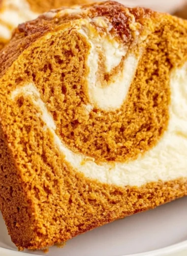 Slice of pumpkin bread with cream cheese frosting on a plate