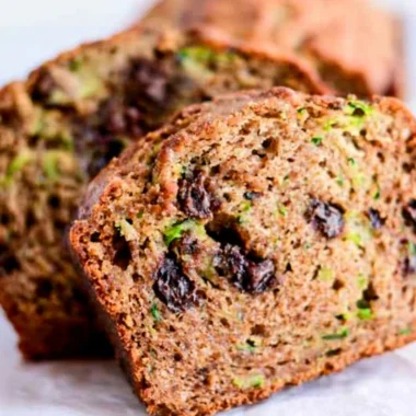 Delicious slice of chocolate chip zucchini bread on a wooden cutting board