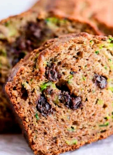 Delicious slice of chocolate chip zucchini bread on a wooden cutting board