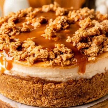 Delicious apple crumble cheesecake topped with cinnamon and crumble on a plate