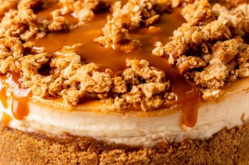 Delicious apple crumble cheesecake topped with cinnamon and crumble on a plate
