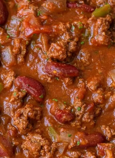 Cozy easy chili recipe, a warm bowl of homemade chili topped with fresh herbs.