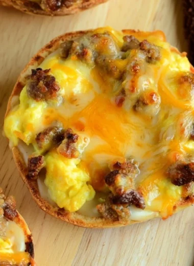 Cozy English muffin breakfast pizza topped with eggs, cheese, and veggies