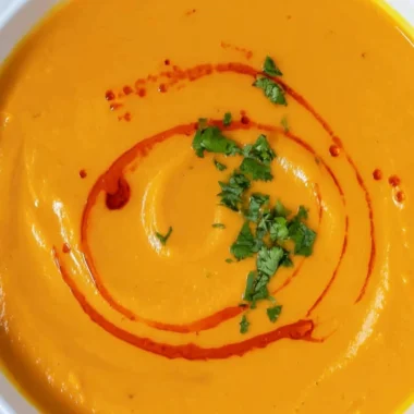 Bowl of cozy sweet potato soup garnished with herbs and spices