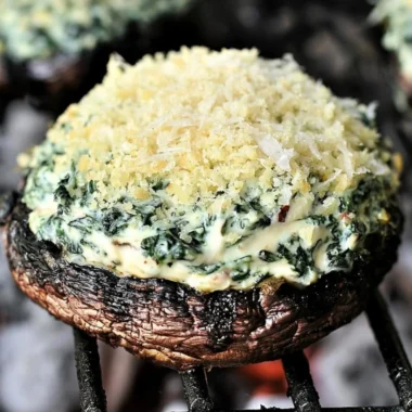 Grilled spinach dip-stuffed portabella mushroom caps served on a plate