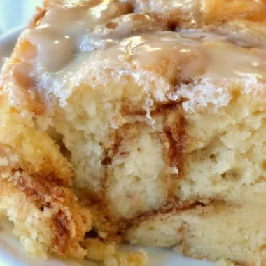 Delicious homemade cinnamon roll cake topped with icing and cinnamon swirls.