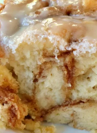 Delicious homemade cinnamon roll cake topped with icing and cinnamon swirls.