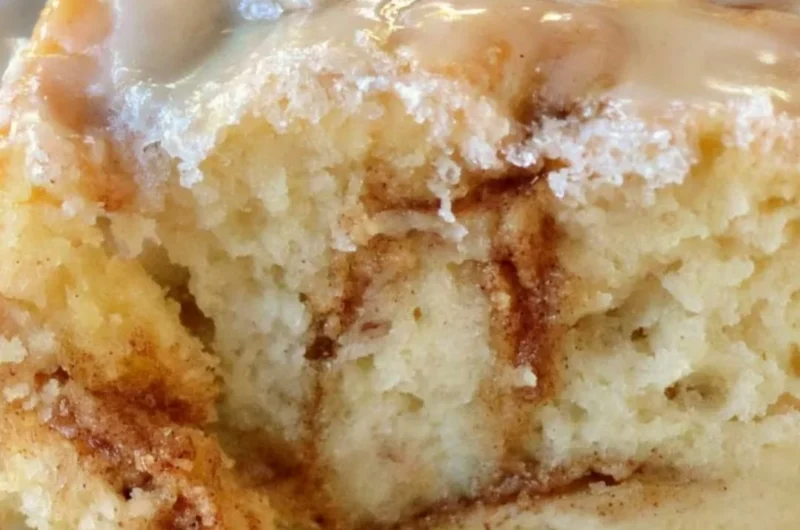 Delicious homemade cinnamon roll cake topped with icing and cinnamon swirls.