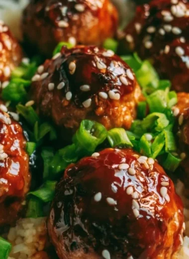 Delicious Asian meatballs served in a bowl with sauce and garnish.