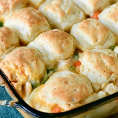 Cozy chicken pot pie topped with flaky biscuits in a rustic dish