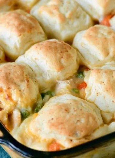 Cozy chicken pot pie topped with flaky biscuits in a rustic dish