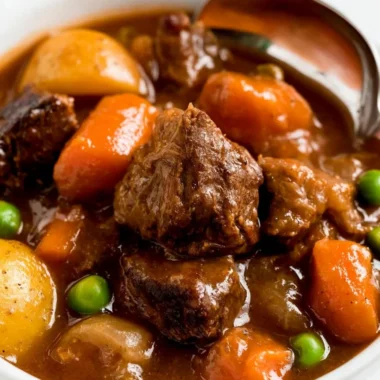 Cozy slow cooker beef stew served in a bowl with vegetables and herbs