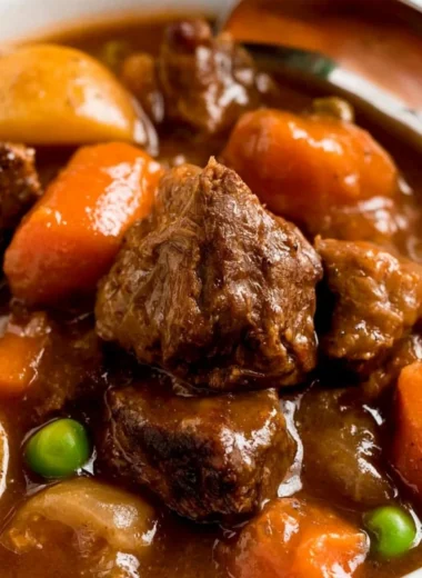 Cozy slow cooker beef stew served in a bowl with vegetables and herbs
