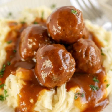Cozy slow cooker Salisbury steak meatballs served with gravy and mashed potatoes