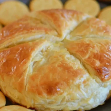 Baked brie in puff pastry served with fruits and nuts