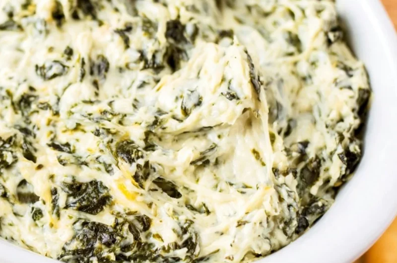 Delicious easy hot spinach dip served in a bowl with bread and vegetables