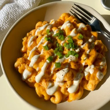 High protein buffalo chicken pasta ready to serve, garnished with herbs.