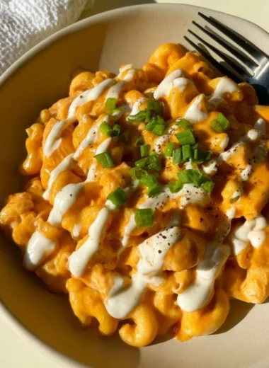 High protein buffalo chicken pasta ready to serve, garnished with herbs.