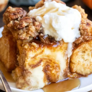 Pumpkin French Toast Casserole topped with syrup and whipped cream