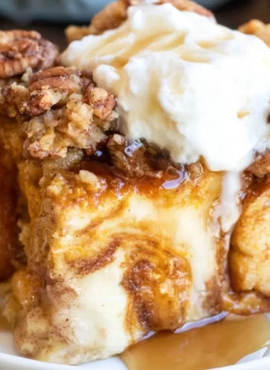 Pumpkin French Toast Casserole topped with syrup and whipped cream