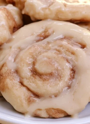 Delicious soft cinnamon roll cookies on a plate with icing