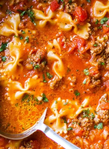 Delicious bowl of the world's best lasagna soup garnished with cheese and herbs.